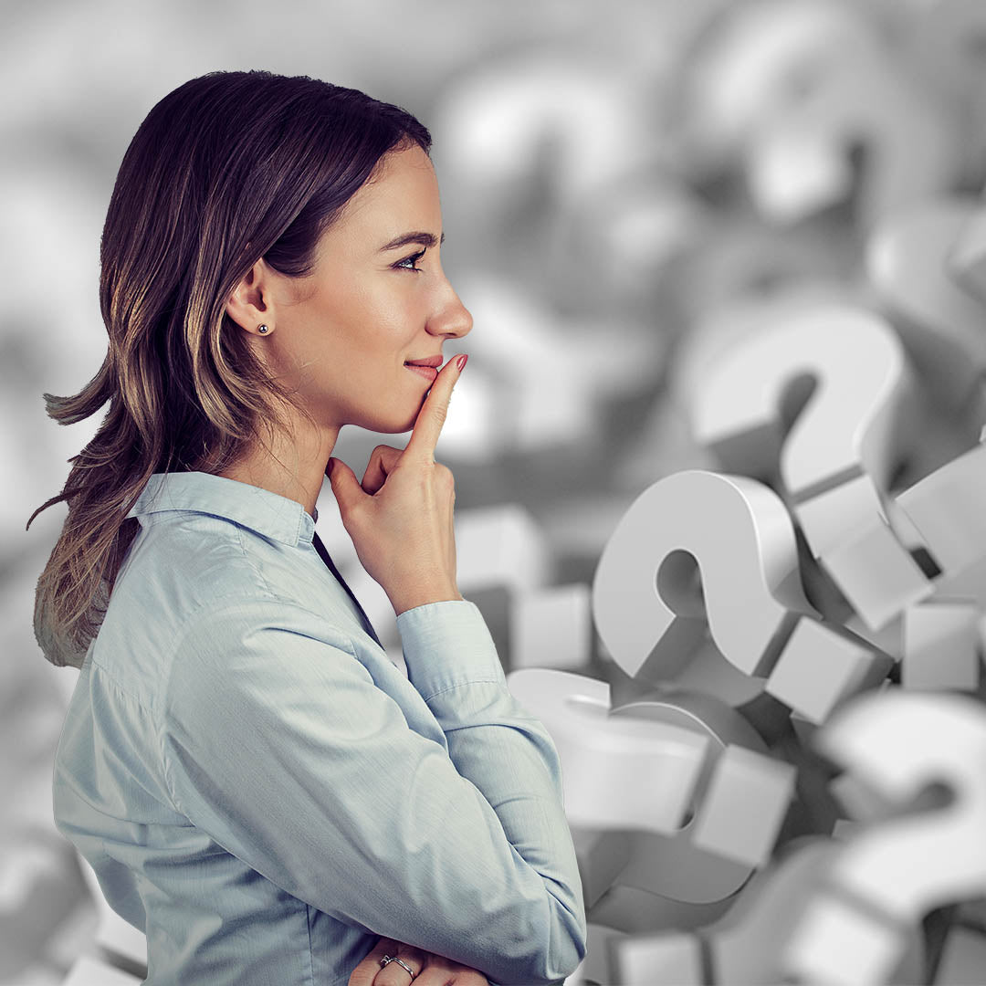 Woman with hand on chin in front of question marks